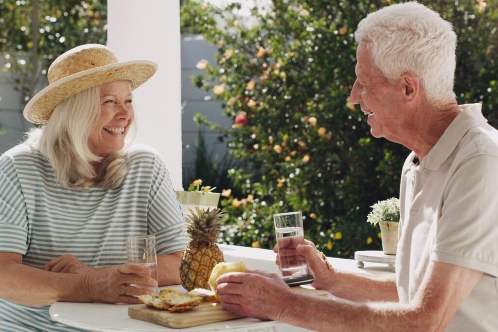 Building Meaningful Connections Later in Life senior couple pineapple patio with water retirement planning vacation anniversary husband wife old garden talk with drink sunshine summer with partner home chat(1)